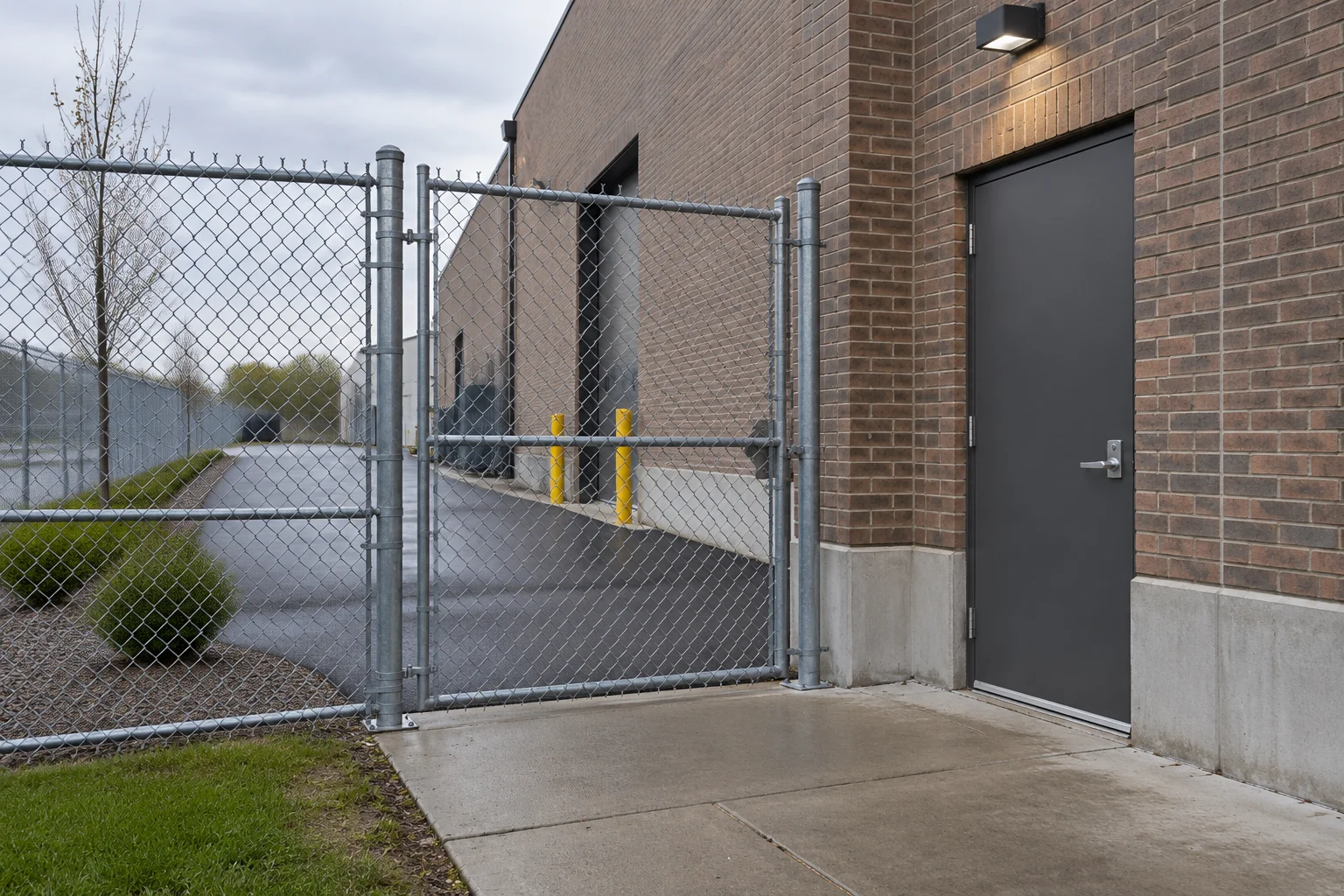 A fenced pedestrian entrance beside a brick commercial building